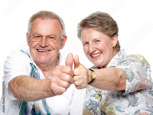 Photo: Closeup portrait of a smiling elderly couple showing thumps Closeup portrait of a smiling elderly couple showing thumps