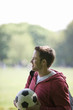 A young man in the park carrying a football