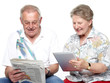 Photo: Seniors reading and having fun with touchpad and newspaper Seniors reading and having fun with touchpad and newspaper