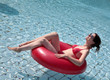 Foto: Junge Frau sitzt im Schwimmreife und geniesst die Sonne Junge Frau sitzt im Schwimmreife und geniesst die Sonne