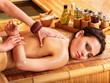 Woman getting massage in bamboo spa.
