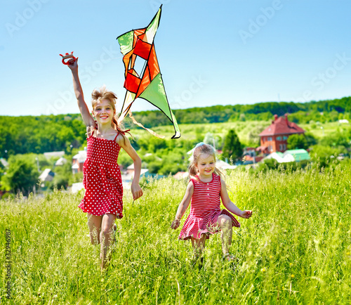 Foto: Kids flying kite outdoor. Kids flying kite outdoor.
