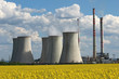 coolin tower and chimney of coal power plant over yellow field