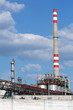 high chimney from oil refinery under sky