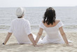 Young couple seating on the beach