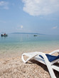 Deck chair on beach with a view at blue sea and island Hvar