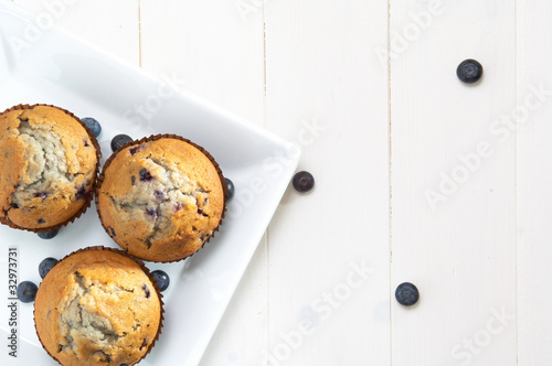 Photo: three muffin on a white square plate, white table three muffin on a white square plate, white table