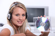a blonde woman listening music and showing a cd a blonde woman listening music and showing a cd