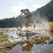 Mountainbiker fährt durchs Wasser