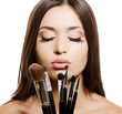 portrait of beautiful woman with makeup brushes