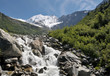 View of high mountains with snow and rapid stream.