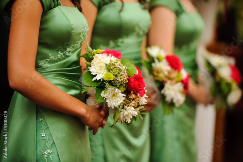 Photo: Row of bridesmaids with bouquets at wedding ceremony Row of bridesmaids with bouquets at wedding ceremony
