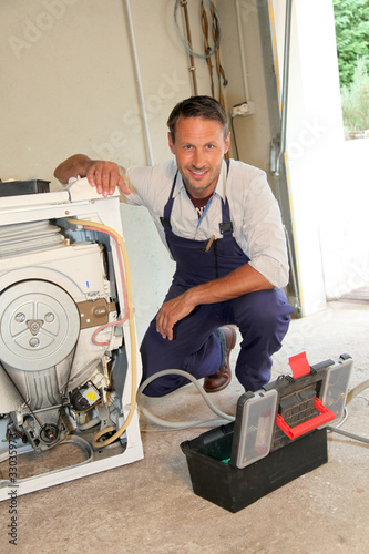 Foto: Plumber fixing washing machine Plumber fixing washing machine