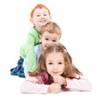 Three smiling kids lying on top of each other Three smiling kids lying on top of each other