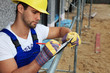Bauarbeiter notiert etwas