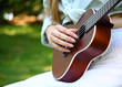 acoustic guitar and the woman hand on green background