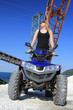 Frau auf dem Quad im Steinbruch vor alten Maschinen