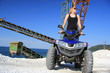 Frau auf dem Quad ATV im Steinbruch vor alten Maschinen