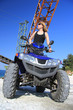 Frau auf dem Quad ATV im Steinbruch vor alten Maschinen