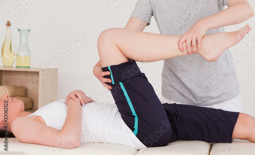 Photo: Masseuse stretching the right leg of an athletic woman Masseuse stretching the right leg of an athletic woman