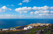 Greek islands with its white buildings white clouds.