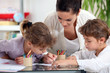 Young woman and little girls making coloring