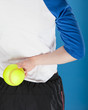 A woman holding a softball behind her back