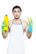 Sad young man in apron holding cleaning sponge and bottle