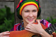Young woman wearing rasta hat with guitar