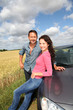 Couple standing by convertible car
