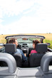Couple riding convertible car