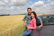 Couple standing by convertible car