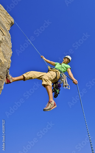 Photo: Rock climber rappelling. Rock climber rappelling.