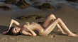 Beautiful exotic young woman lying on beach