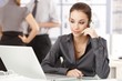Young office worker using headset sitting at desk