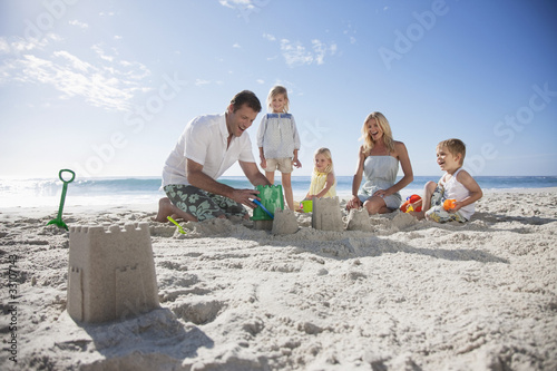 Photo: Family making sand castles on beach Family making sand castles on beach