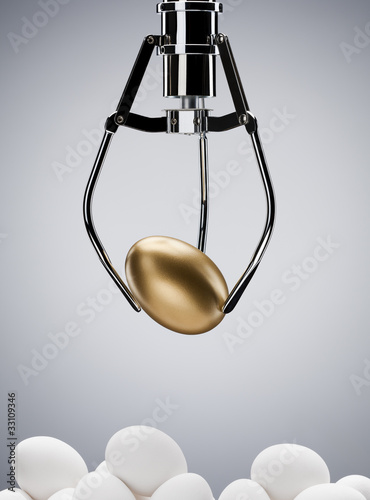 Photo: Mechanical claw lifting golden egg Mechanical claw lifting golden egg