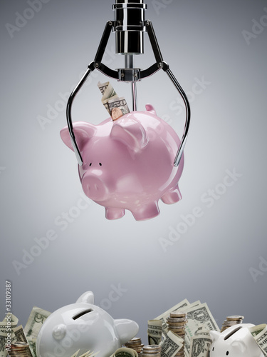 Photo: Mechanical claw lifting piggy bank Mechanical claw lifting piggy bank
