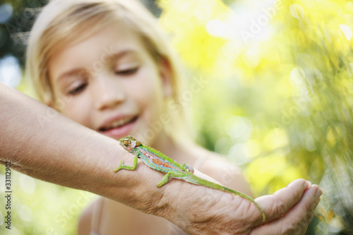 Foto: Girl watching lizard on grandmother?s arm Girl watching lizard on grandmother?s arm