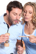 a couple cooking and watching a wooden spoon
