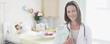 Portrait of pediatrician in hospital with patient in background