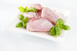 Raw rabbit meat on a plate. Arrangement with mint leaves.