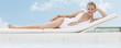 Woman laying on lounge chair at poolside