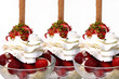 Drei leckere Erdbeereisbecher mit Sahne, Waffel und Pistazie Drei leckere Erdbeereisbecher mit Sahne, Waffel und Pistazie