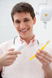 Man in dentist's office holding toothbrush and toothpaste