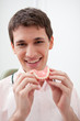Man in dentist's office holding false teeth