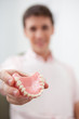 Man in dentist's office holding false teeth