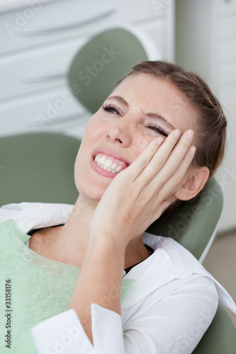 Photo: Woman having toothaches in dentist's chair Woman having toothaches in dentist's chair