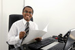 Happy business man or accountant reading documents at desk