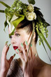 Beauty Frau mit grünem Kopfschmuck blickt fern